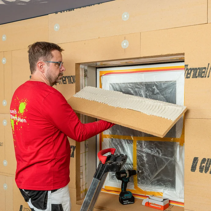 Die Holzfaserdämmplatte für die Laibung im Fenstersturz ist mit Klebemörtel vorbereitet und wird vom Handwerker in den Fenstersturz geklebt. Innendämmung zum Selbermachen von Baumit.