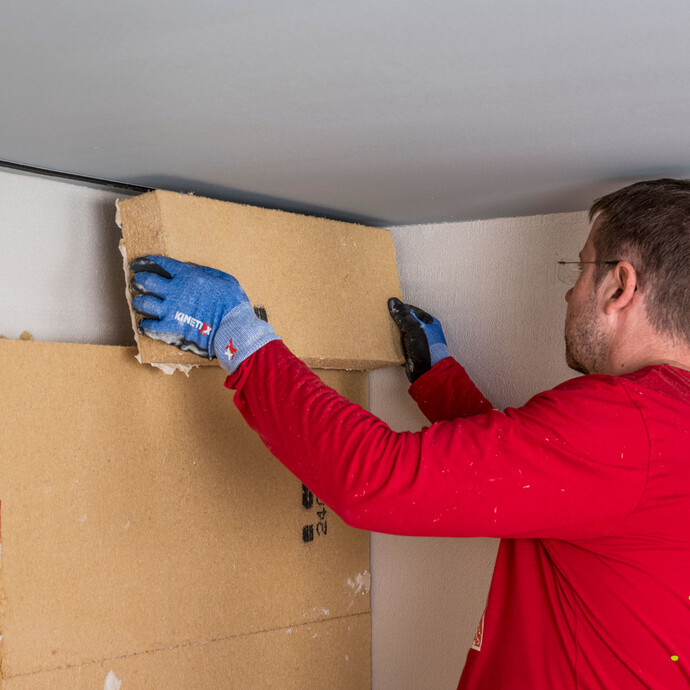 Heimwerker klebt die letzte Holzfaserdämmplatte als Innendämmung direkt unter die Decke. Anleitung Baumit Selbermachen.
