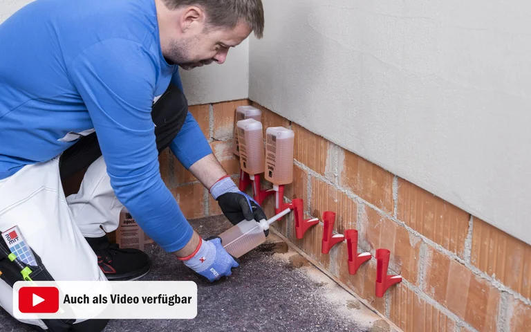 Handwerker injiziert Mauerwerkssperre gegen Feuchtigkeit zur Vermeidung von Schimmelbildung in Kellerwänden.