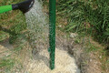 Mit einer Gießkanne wird Wasser auf den Garten- und Landschaftsbaubeton Fix geschüttet.