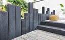 Moderne Terrasse grauen, hellen Steinplatten und Palisaden in Anthrazit.