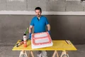 Heimwerker füllt Schalungsform mit Bauschaum auf Werkbank für DIY-Projekt.