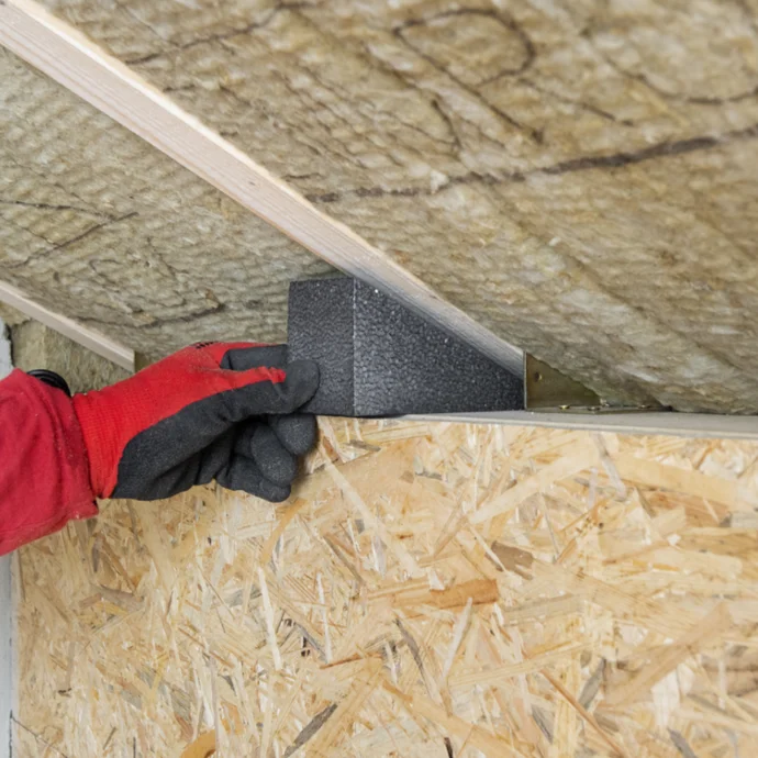 Dämmmaterial wird zwischen Wand und Decke eingebaut, um die energetische Effizienz zu verbessern.