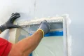 Heimwerker setzt Eckschutzschiene an Fensterlaibung für perfekten Putzabschluss.