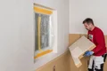 Die Holzfaser-Dämmplatte Thermoroom wird an die Wand geklebt.