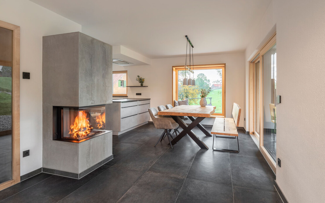 Wohnzimmer in modernem Design mit Kamin in Betonoptik, Granitboden und moderner Einrichtung mit wohngesundem, feinem, brillantwei&szlig;em Strukturputz InStyle Edelwei&szlig;.