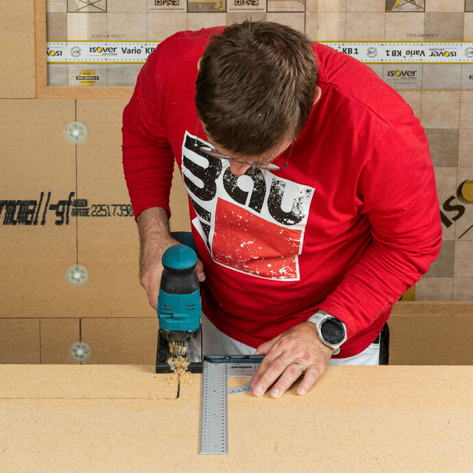 Baumit Heimwerker schneidet die Holzfaserdämmplatte mit einer Stichsäge zu.