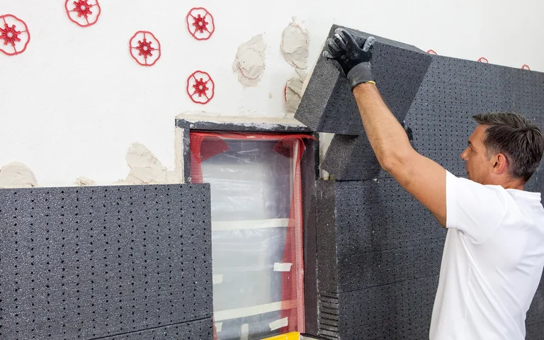 Heimwerker bringt EPS oder Open ERPS Dämmplatten an Fassade an
