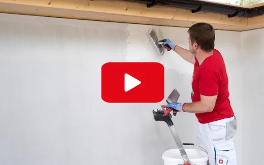 Heimwerker trägt Putz auf Hauswand auf, mit Kelle und Abziehwerkzeug, Schritt-für-Schritt-Anleitung auf Baumit Selbermachen.