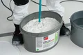 Detailfoto: Der Airless- und Rollspachtel Silikat wird mit einem elektrischen Rührwerk aufgerührt.