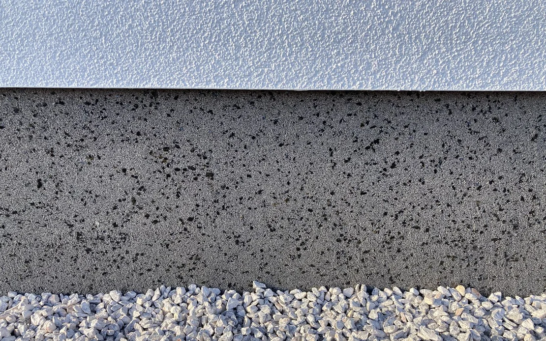 Der Sockel ist mit Sockelputz verputzt in Kombination mit einem wei&szlig;en, feinen Strukturputz.