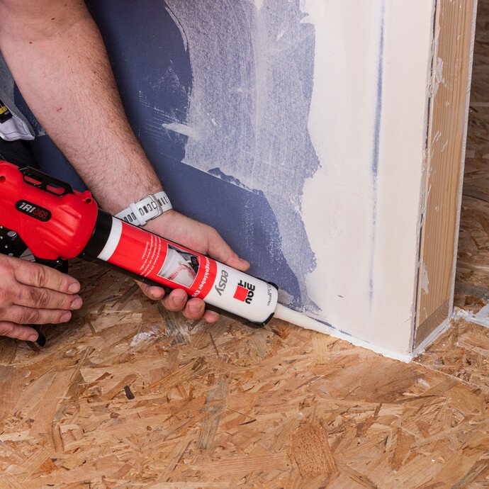 Detailaufnahme: Der Stoßbereich von der Spanplatte zur Trockenbauwand wird mit easy Montagekleber EVO von Baumit abgedichtet.