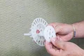 Person hält einen Kunststoff-Dübel mit Dämmteller, ideal zur Befestigung von Dämmplatten an Hausfassaden.