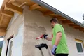 Heimwerker streicht das Mauerwerk kräftig mit Tiefengrund ein.