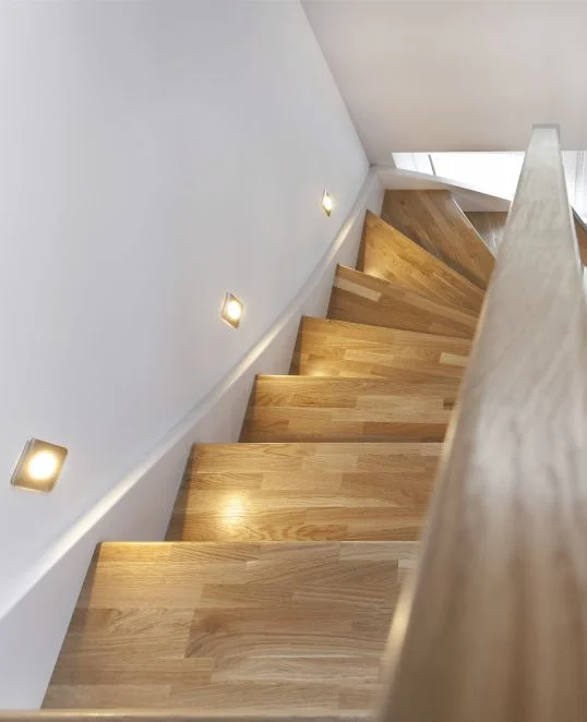 Holztreppe mit integrierter Wandbeleuchtung für sicheres Heimwerken und stilvolle Renovierungsideen.