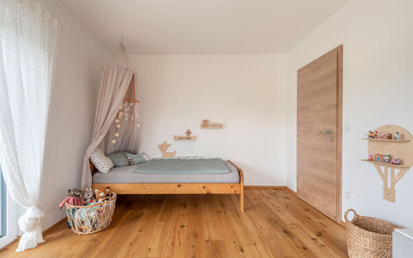 Modernes Kinderzimmer mit Bett und Spielzeug, Holzboden und dem brillantweißen Edelputz InStyle Edelweiß mit gefilzter Putzstruktur für ein angenehmes Raumklima.