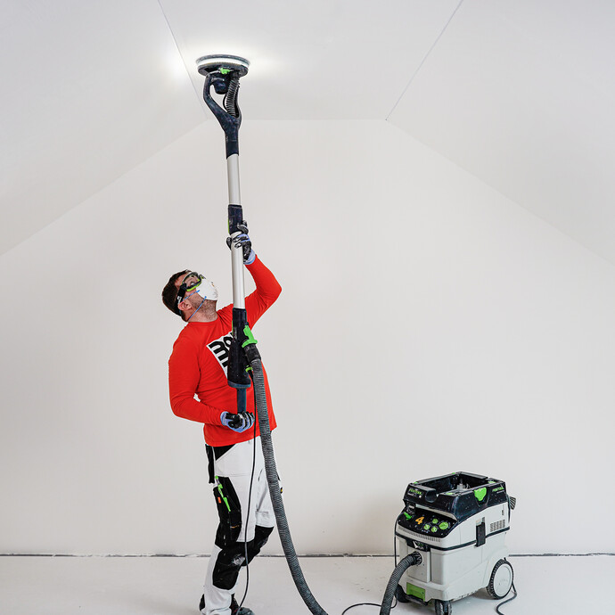 Die Decke wird mit dem Trockenbauschleifer geglättet.