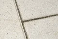 Nahaufnahme einer verfugten Terrassenplatte mit Betonsteinbelag, ideal für moderne Außenbereiche und DIY-Projekte.