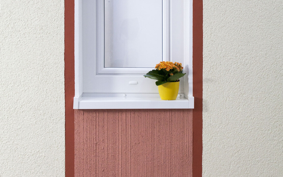 Ein  Fenster mit zwei dicken roten Streifen rechts und links. Unter sowie über dem Fenster sind die Streifen mit hellroter Farbe ausgefüllt.