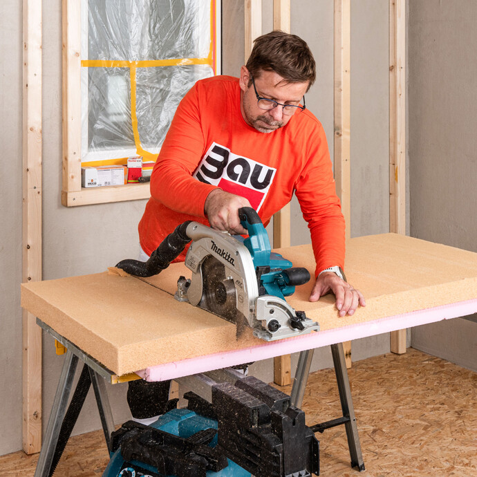 Heimwerker schneidet die Holzfaserdämmplatte Thermoflex mit einer Handkreissäge von Makkita zu. Stichsäge, Fuchsschwanz sind nicht geeignet - damit bekommt man keine glatte, saubere, gerade Schnittkanten. Baumit Selbermachen Anleitung für Heimwerker.