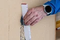 Hand glättet Baustoffoberfläche mit Baumit-Werkzeug, präzise Verarbeitung von Heimwerkerprojekten für perfekte Ergebnisse.