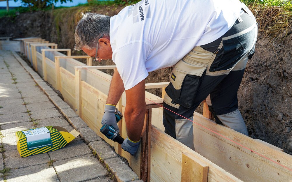 Gartenmauer bauen erste Reihe Mauersteine setzen Gartensteine