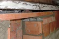 Backsteinmauer mit sichtbaren Schäden; geeignet für Anleitungen zu Reparatur- und Sanierungsprojekten.