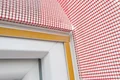 Fensterrahmen mit rotem Putzgewebe für sicheren Halt und wirksame Abdichtung vorbereitet.