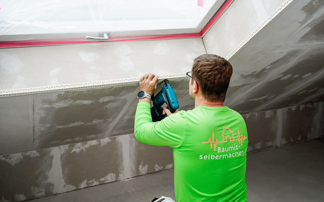 Das zugeschnittene Kantenschutzprofil wird am unteren Abschluss der Dachfenstereröffnung angebracht.