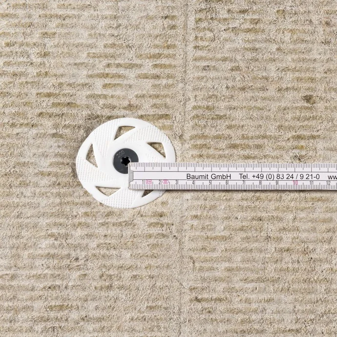 Maßband auf Dämmplatte, zeigt präzise Befestigung mit Dübel für exakte DIY-Installationen mit Baumit-Produkten.