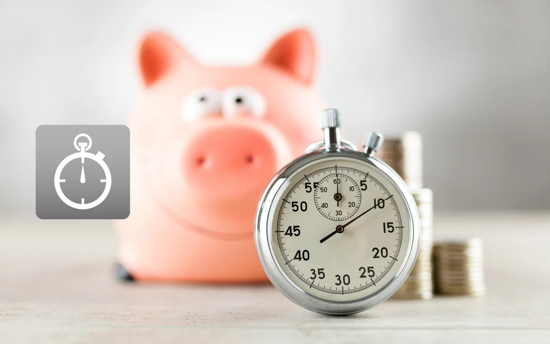 Eine Stoppuhr vor einem Sparschwein und M&uuml;nzen, Symbol f&uuml;r Zeitersparnis bei DIY-Projekten mit Baumit.