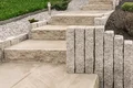 Natursteintreppe im Garten mit dekorativen Steinen, ideal für Heimwerkerprojekte zur Verschönerung des Außenbereichs.