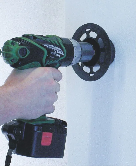 Akkubohrer durchbohrt leicht eine Wand zur Installation einer Steckdose.
