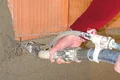 Handwerker verputzt Ziegelwand mit Spritzgerät, detaillierte Anleitung und Tipps auf Baumit-Selbermachen.de.