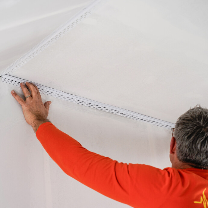 Zugeschnittene Anschlussprofil wird in den vorgesehenen Spalt eingeführt.