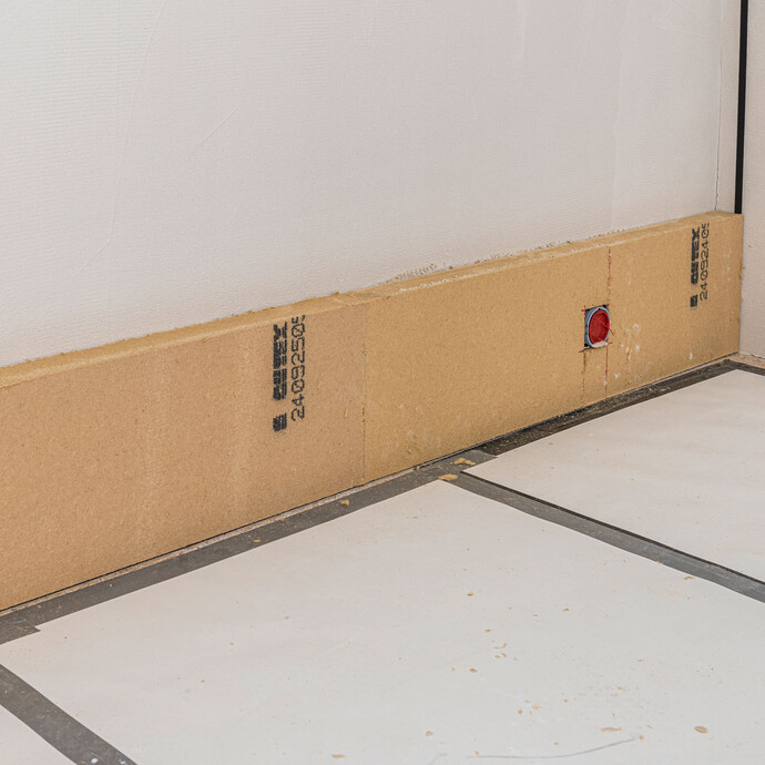 Fluchtgerecht und lotrecht geklebte erste Reihe Baumit Holzfaserdämmplatten als Innendämmung an der Wand – exakte Ausrichtung der ersten Dämmplattenreihe als Grundlage für alle weiteren Reihen, Baumit Selbermachen Anleitung.