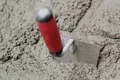 Kelle beim Verarbeiten von Mörtel auf rauer Oberfläche, ideal für DIY-Projekte zur Wandverkleidung oder Estrichverlegung.