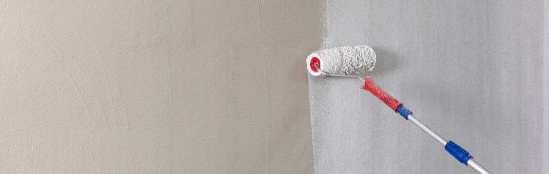 Wand wird mit großer Farbrolle mit weißer Baumit Universalgrundierung grundiert.