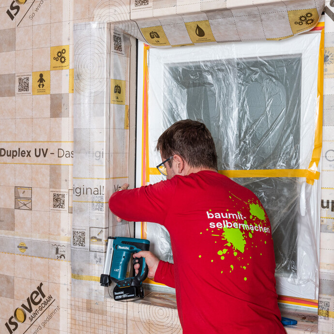 Baumit Handwerker tackert das Folienstück der Dampfbremse direkt in der Laibung des Fensters am Tragholz fest. So sitzt die Dampfbremse sicher. Dampfbremse in der Laibung richtig montieren - Schritt für Schritt erklärt.
