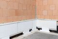 Die Baumit Sockeldämmplatten sind im ersten Schritt entlang des Hauses geklebt.