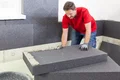 Heimwerker montiert Dämmplatten im Innenbereich mit Baumit Materialien für effektive Wärmedämmung.