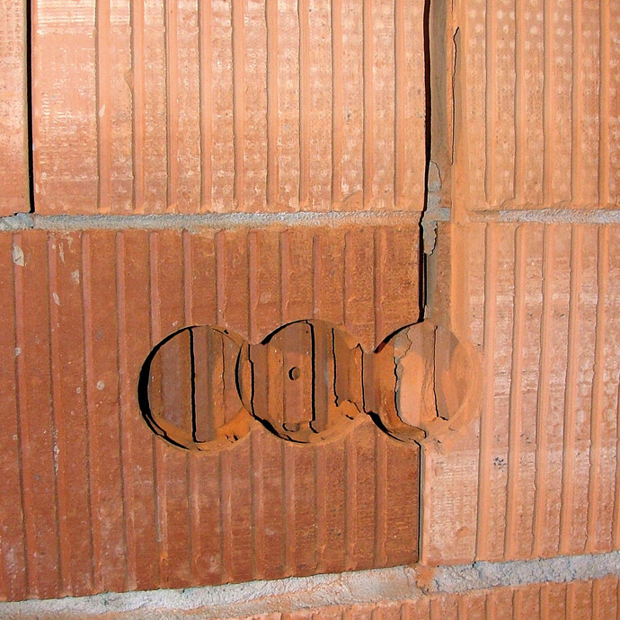 Ziegelmauerwerk mit mit vorbereiteten Schlitzen und Ausfräsungen zum Anbringen der Elektrodose und des Leerrohrs für die Kabel.