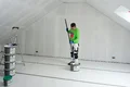 Der Heimwerker taucht die Walze in den verarbeitungsfertigen Rollspachtel.