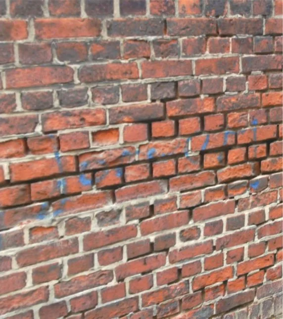 Nahaufnahme einer roten Ziegelmauer mit ungleichmäßigem Mauerwerk, ideal zur Planung von Renovierungs- oder Sanierungsarbeiten.