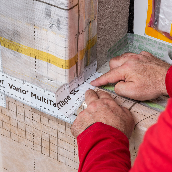 Im Bereich der Fensterbank wird ein Klebebandstreifen über die Kante geklebt. Der Streifen muss bündig zur Innenkante der Fensterlaibung sein. So wiird die Dampfbremse in der Laibung abgedichtet.