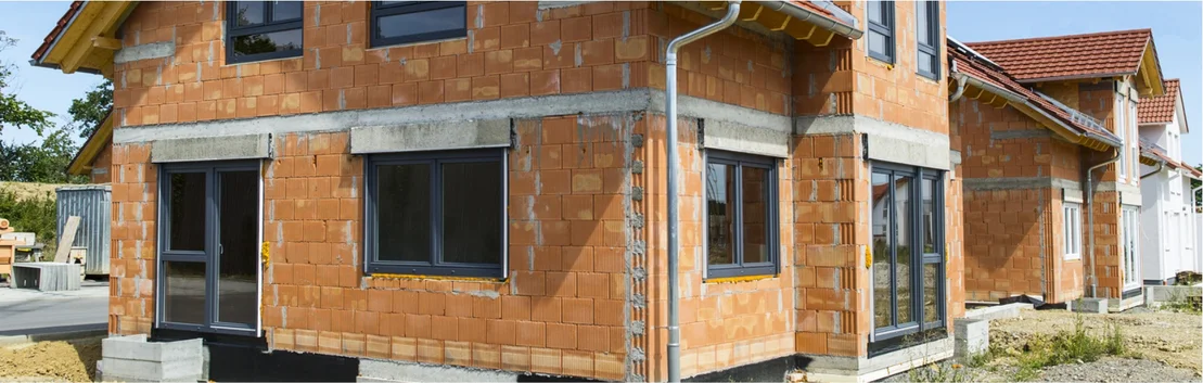 Neubau eines Einfamilienhauses mit unverputzten Ziegelau&szlig;enw&auml;nden und modernen Fenstern.