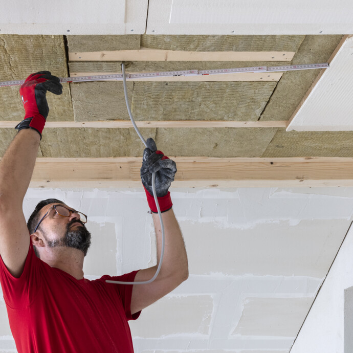 Maße für die Kabeldurchführung der Beleuchtung an der Trockenbaudecke ausmessen