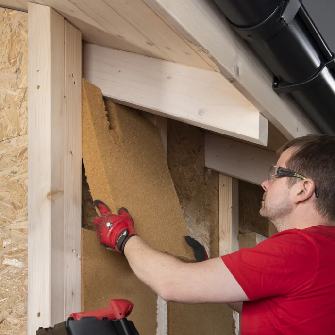 Heimwerker dämmt Dachschrägen mit Holzfaserdämmplatten für energieeffiziente Isolierung.